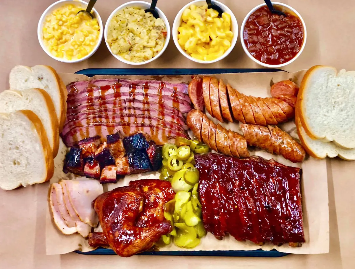 Slap's BBQ catering tray with brisket, burnt ends, ribs, sausage, chicken, turkey and sides