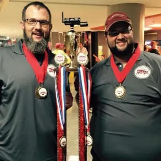 Slap's BBQ pitmasters Mike and Joe with their trophy and medals from a Kansas City BBQ competition